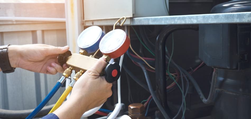 A technician performing air conditioning maintenance and checking for possible problems.