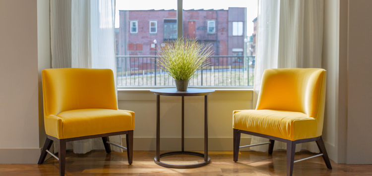 two yellow chairs near window