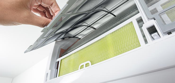 A person is inspecting the air filter in his HVAC system.